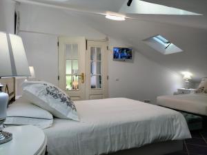 um quarto branco com 2 camas e uma janela em ATTIC BAY em Câmara de Lobos