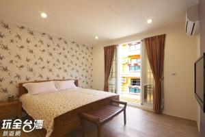 a bedroom with a bed and a window at Kenting Lian Nan Wan in Nanwan