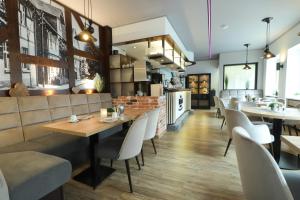 a dining room with tables and white chairs at Hotel Am Dalwigker Tor in Korbach