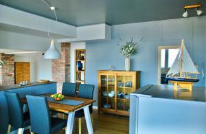 a dining room with a table and a boat on the wall at Dachloft MEERzeit in Barth