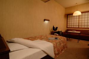 a hotel room with a bed and a window at Hotel Iida in Kyoto
