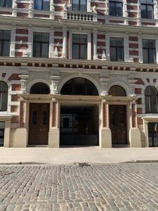 a building with two doors and a cobblestone street at Verman Park Apartment in Rīga