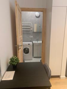 a kitchen with a table and a washing machine at Verman Park Apartment in Rīga