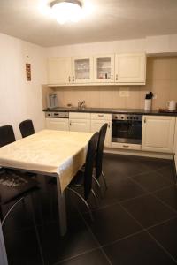 a kitchen with white cabinets and a table and chairs at Gruyère Rooms in Gruyères