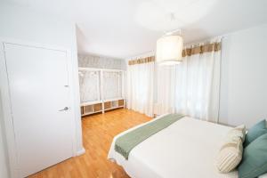 ein Schlafzimmer mit einem weißen Bett und einer weißen Tür in der Unterkunft VILLA ANTALA - El Rincón de Marañón in Córdoba