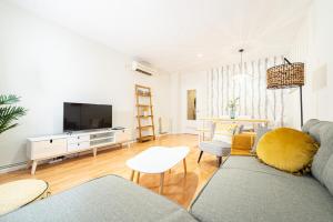 ein Wohnzimmer mit einem Sofa und einem TV in der Unterkunft VILLA ANTALA - El Rincón de Marañón in Córdoba