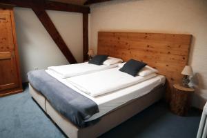 a bedroom with a large bed with a wooden headboard at Gruyère Rooms in Gruyères