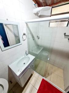 a bathroom with a shower and a sink and a toilet at Pousada Canto Nosso in São Pedro da Serra