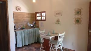 una cucina con tavolo, sedie e bancone di Chalé Juliet a Pirenópolis