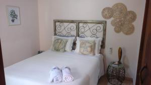 Un dormitorio con una cama con zapatillas. en Chalé Juliet en Pirenópolis
