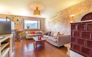 ein Wohnzimmer mit 2 Sofas und einer Küche in der Unterkunft Pozza Appartamenti in Carano