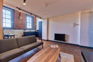 No 8 at Simpson Street Apartments Sunderland في سندرلاند: غرفة معيشة مع أريكة وطاولة