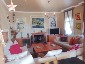 Una sala de estar con sofás blancos y una chimenea. en La huerta de Bonela, en Casarabonela