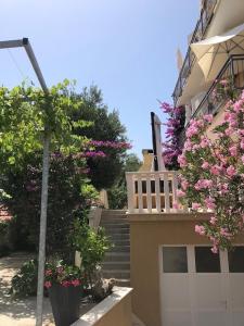 uma casa com uma porta de garagem branca e flores cor-de-rosa em I.K. APARTMENTS em Orebić