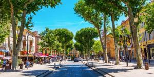a street in a city with trees and buildings at TERRASSE PROVENCE PAGNOL***** in Aubagne