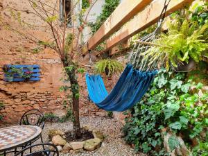 a hammock hanging from a wall in a garden at Casa Font in Benissanet