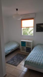 - une chambre avec 2 lits et une fenêtre dans l'établissement LES EMBRUNS - SPACIEUX APPARTEMENT AVEC PISCINE, à Saint-Cyprien