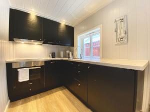 SennesvikにあるRorbu 8 Middagstinden - Ure Lofotenのキッチン(黒いキャビネット、カウンタートップ付)