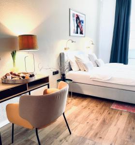 1 dormitorio con 1 cama, 1 mesa y 1 silla en Piesteritzer Hof - Hotel Garni en Lutherstadt Wittenberg