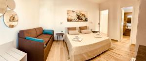 um pequeno quarto com uma cama e um sofá em Bonaventura em Porto Cesareo