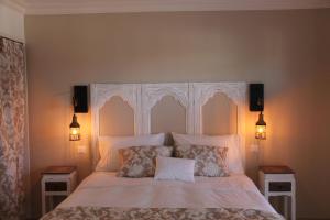 um quarto com uma cama branca com duas mesas de cabeceira em Le Clos 24 em Macherin