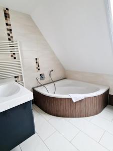 a bathroom with a bath tub and a sink at DM Hotes & Apartments - Apartment Pfarrgasse 09 in Küllstedt
