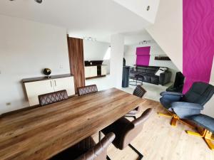 ein Wohnzimmer mit einem großen Holztisch und Stühlen in der Unterkunft DM Hotels & Apartments - Apartment Pfarrgasse 09 in Küllstedt