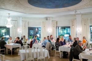 een groep mensen die aan tafel zitten in een restaurant bij Hotel Vännäs in Vännäs