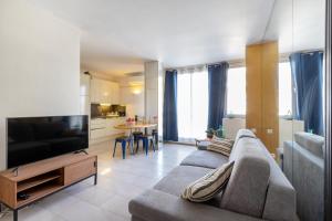 a living room with a couch and a television at 45 Croisette Apartment - Prime Location - Beach & Palais by Foot - AC in Cannes +3 photos