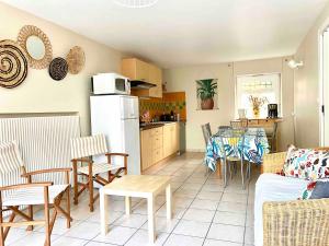 eine Küche und ein Wohnzimmer mit einem Tisch und einem Kühlschrank in der Unterkunft Les Gites Du Moulin Du Port in Saint-Georges-sur-Cher