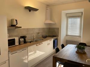 a kitchen with a table and a microwave at L’atelier d’Auguste in Marcols-les-Eaux