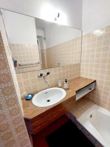 a bathroom with a sink and a mirror and a tub at Chbre Tamara du Château avec Piscine in Pépieux