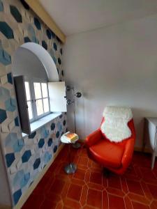 a room with a red chair and a window at Chbre Tamara du Château avec Piscine in Pépieux