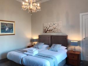 um quarto com uma cama e um lustre em Alexander Guest House em Edinburgo