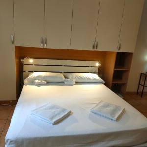 een groot wit bed met 2 handdoeken erop bij Dolce Milano in Milaan