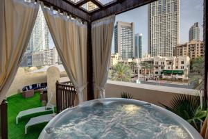 uma banheira numa varanda com vista para a cidade em Durrani Homes - Unique Garden Apt at Souk Al Bahar besides Dubai Mall & Burjkhalifa with private jaccuzi em Dubai