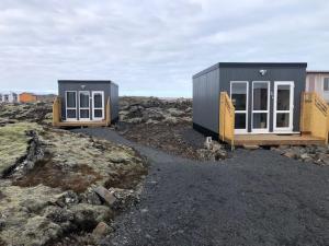 duas minicasas sentadas em cima de algumas rochas em Reykjavík Outskirts - Minimalist Escape em Vogar