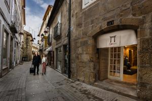 Um homem e uma mulher a andar numa rua em Viseu Ryokan - Hospedaria Japonesa & SPA em Viseu