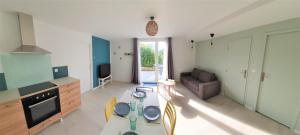 eine Küche und ein Wohnzimmer mit einem Tisch und einem Sofa in der Unterkunft LA PIERRINA - Marmotte - Appart 3 étoiles in Aix-les-Bains
