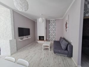 a living room with a couch and a tv at Central Star in Daugavpils