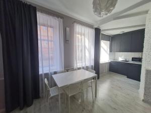 a kitchen with a table and chairs in a room at Central Star in Daugavpils