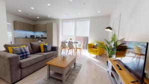 ein Wohnzimmer mit einem Sofa und einem Tisch in der Unterkunft Luxury Apartment - Town Centre North Stevenage in Stevenage
