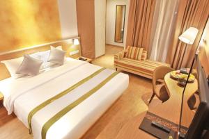 a hotel room with a bed and a chair at Liberta Hotel Jimbaran in Jimbaran