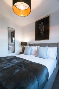 a bedroom with a large bed and a lamp at The Lusso Suite - 2BR - A 5* Escape Like No Other in Glasgow