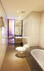 Liberta Hotel Jimbaran في جيمباران: حمام مع مرحاض وحوض استحمام ومغسلة