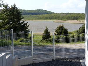 a fence with a view of a body of water at Ferienvilla mit Panoramablick auf den Schmachter See in Binz +17 photos