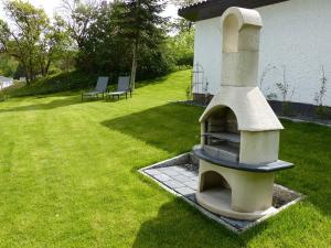 a outdoor oven sitting on a lawn in a yard at Ferienvilla mit Panoramablick auf den Schmachter See in Binz