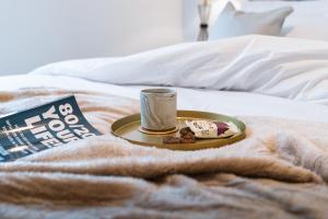 a plate of food and a cup on a bed at The Lusso Suite - 2BR - A 5* Escape Like No Other in Glasgow