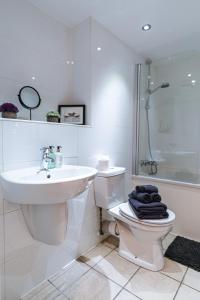 a bathroom with a toilet and a sink and a shower at The Lusso Suite - 2BR - A 5* Escape Like No Other in Glasgow