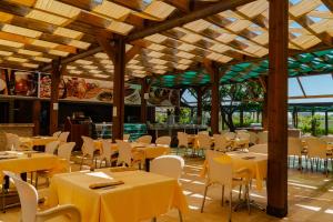 a restaurant with tables and white chairs and a ceiling at Royal Atlantis Spa & Resort in Side